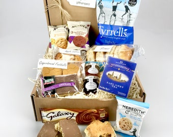 Può includere: Una scatola regalo marrone piena di vari snack e dolcetti, tra cui biscotti al cioccolato, biscotti di pan di zenzero a forma di pallone da calcio, bustine di tè e una busta di patatine inglesi Tyrrells cotte a mano. La scatola contiene anche una barretta di cioccolato Galaxy e una busta di biscotti Meredith & Drew.
