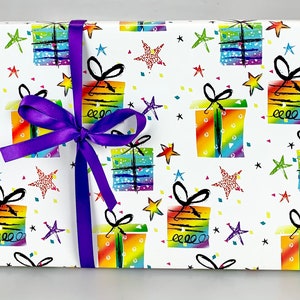 Puede incluir: Papel de regalo blanco con un patr&oacute;n de caja de regalo arco&iacute;ris colorido y estrellas negras. Una cinta morada est&aacute; atada alrededor del papel de regalo.