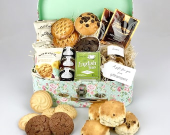 May include: A green and white floral patterned gift box filled with a variety of treats, including scones, biscuits, tea, hot chocolate, and pastries. The box has a handle and is labeled "A gift for you from gifthamperz".