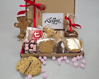 May include: A brown cardboard gift box tied with a red ribbon, filled with various vegan treats. Includes cookies, a gingerbread man, marshmallows, and a card that says "Vegan".