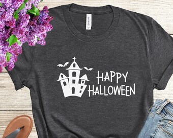 May include: A dark gray t-shirt with a white graphic of a haunted house and bats with the text "Happy Halloween".