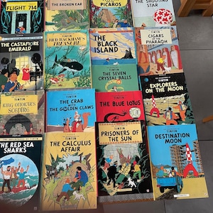 Peut inclure: Une collection de bandes dessin&eacute;es Tintin, pr&eacute;sentant divers titres aux couvertures color&eacute;es. Les titres incluent "Vol 714 pour Sydney", "L'Oreille cass&eacute;e", "Les Bijoux de la Castafiore" et "Le Tr&eacute;sor de Rackham le Rouge". Les livres sont dispos&eacute;s sur une surface.