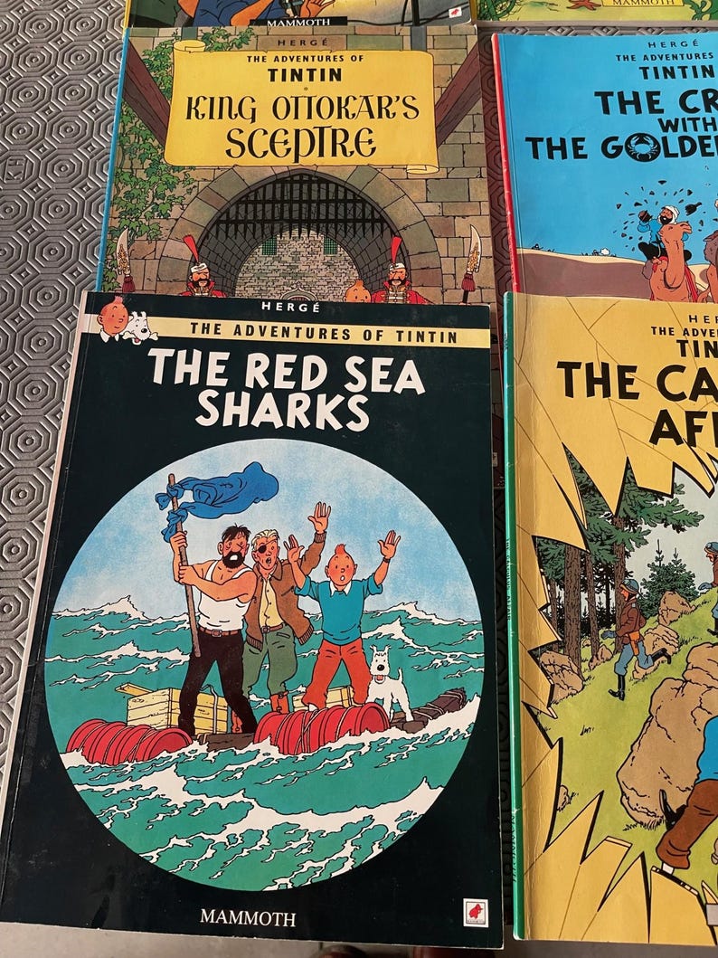 Peut inclure: Plusieurs bandes dessin&eacute;es Tintin avec des couvertures color&eacute;es. Les titres incluent "Le Sceptre d'Ottokar" et "Les Requins de la Mer Rouge". Les livres sont publi&eacute;s par Mammoth.