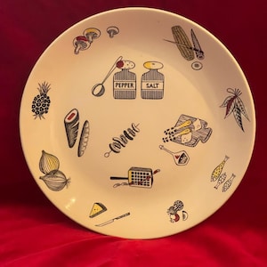 Può includere: Un piatto color crema, in stile vintage, con illustrazioni in bianco e nero di alimenti. Il piatto presenta immagini di funghi, ananas, cipolle, mais, pesce e uno spiedino. Le parole "PEPPER" e "SALT" sono stampate.