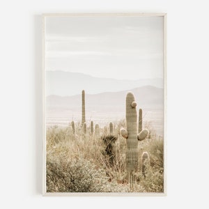 May include: A photograph of a desert landscape with a row of tall cacti in the foreground. The cacti are green and have a light brown color. The background is a hazy, light brown color with a mountain range in the distance.