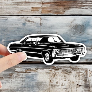 May include: Black and white silhouette of a classic car, a 1967 Chevrolet Impala, on a wood background.
