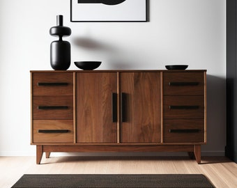 May include: A mid-century modern style wooden dresser with four drawers and two cabinet doors. The dresser is made of walnut wood and has black metal hardware. The dresser is sitting on a black and white patterned rug.