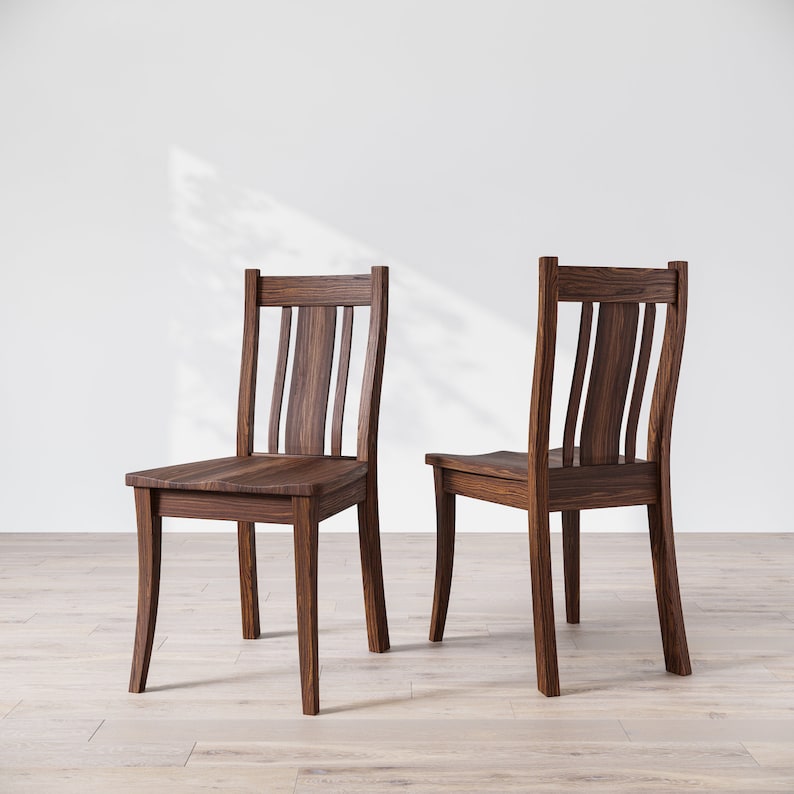 May include: Two dark brown wooden chairs with a simple design. The chairs have a slatted back and a curved seat.