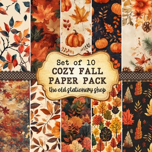 May include: A collection of 10 "Cozy Fall Paper Pack" sheets featuring autumnal designs. The sheets display watercolour illustrations of pumpkins, maple leaves, and fall foliage in orange, brown, and green hues. The text "the old stationery shop" is also visible.