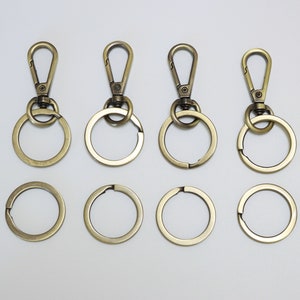 May include: Set of ten gold-toned metal keychains. Five keychains feature a swivel clasp and a round ring. Five keychains feature a round ring only.