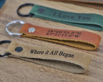 May include: Four leather keychains with different engravings. The keychains are brown, tan, green, and dark brown. The engravings include "I Love You", "38°00'55.0"N 87°31'15.0"W", "Where it All Began", and "JEREMY".