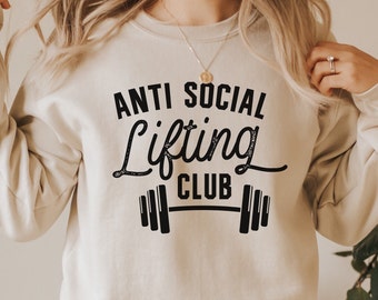 May include: A beige sweatshirt with the text "Anti Social Lifting Club" in black lettering with a barbell graphic.