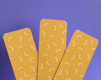 May include: Three yellow bookmarks with a repeating pattern of white macaroni shapes. The bookmarks are arranged in a fan shape.