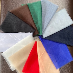 May include: Assortment of 10 different colors of tulle fabric swatches. The colors are black, brown, green, light blue, white, beige, red, peach, blue, and navy.