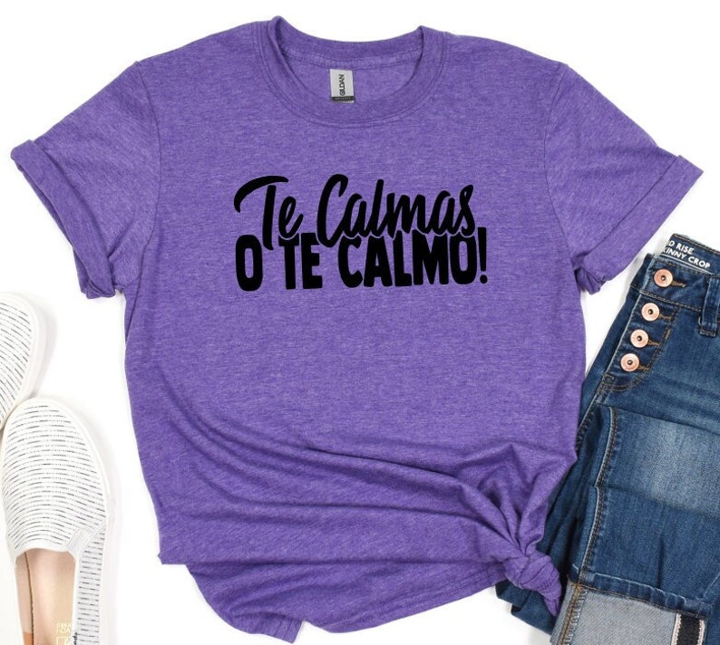 Puede incluir: Camiseta morada con el texto "Te Calmas o Te Calmo!" en negro.