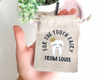 May include: A small, beige, burlap drawstring bag with a white tooth fairy design and the text "For the Tooth Fairy from Louis".