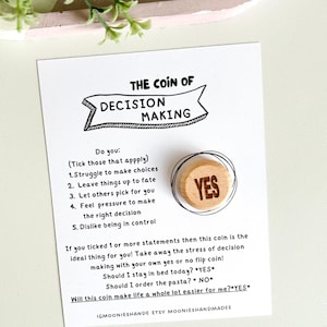 May include: A wooden coin with the word "YES" printed on it. The coin is part of a decision-making kit that helps people make choices. The kit includes a card with a list of statements about decision-making and instructions on how to use the coin.
