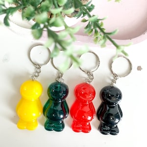 May include: Four jelly bean shaped keychains in yellow, green, red, and black.