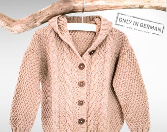 Könnte beinhalten: Ein beiger Strickcardigan mit Kapuze und Knopfleiste. Der Cardigan hat ein Zopfmuster und hängt an einem Holzast.