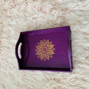 Puede incluir: Bandeja de servir de madera p&uacute;rpura con un dise&ntilde;o de mandala dorado.