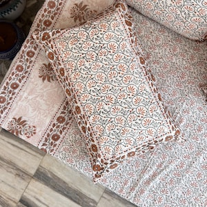 May include: A white cotton pillowcase with a floral pattern in shades of orange and gray. The pillowcase has a border of orange and gray floral print.