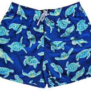May include: Blue swim trunks with a repeating pattern of green and yellow sea turtles.