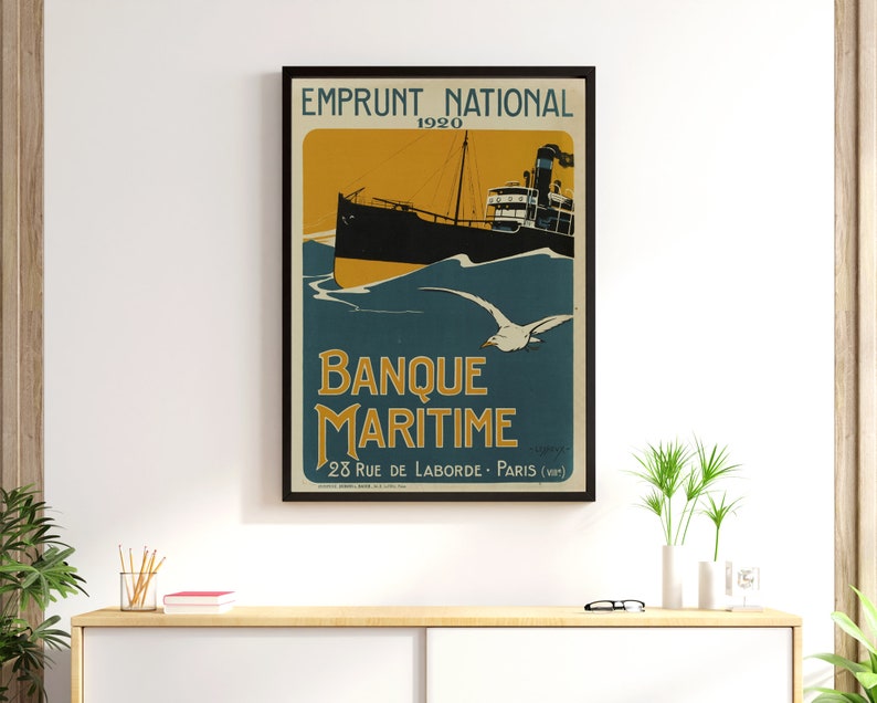 May include: A vintage poster advertising Banque Maritime, a French bank, with the text "Emprunt National 1920" and "Banque Maritime 28 Rue de Laborde - Paris (VIII)" in a black frame. The poster features a black and white illustration of a ship sailing on a blue sea with a seagull flying overhead.