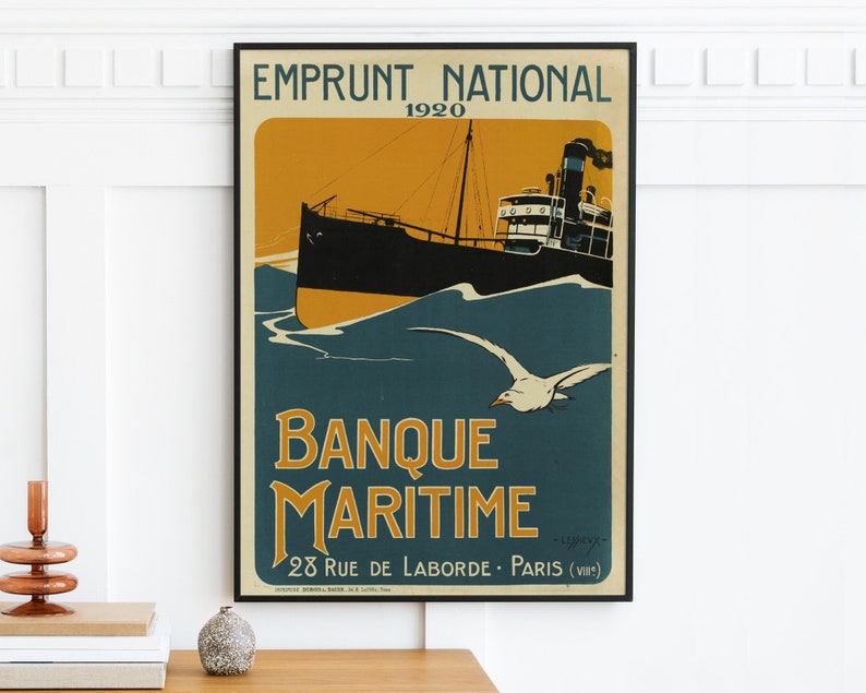 May include: A vintage poster advertising Banque Maritime, a French bank, with the text "Emprunt National 1920" and "Banque Maritime 28 Rue de Laborde - Paris (VIII)". The poster features a black and white illustration of a ship sailing on a blue sea with a seagull flying overhead.