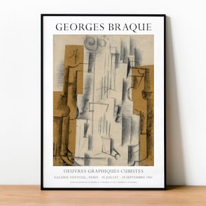 May include: A framed art print featuring a cubist artwork by Georges Braque. The print has a black frame and displays a monochromatic drawing with tan and gray tones. Text at the top reads "Georges Braque" and at the bottom "Oeuvres Graphiques Cubistes".