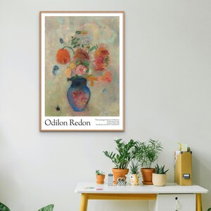 May include: A vintage poster featuring a still life painting of a blue vase filled with pink, red, and orange flowers. The artist's name, Odilon Redon, is printed at the bottom of the poster, along with the title of the painting, "The Lessing J. Rosenwald Collection".