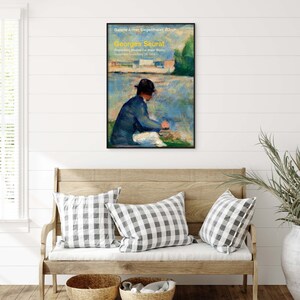 May include: A vintage poster for an art exhibition featuring a painting of a woman sitting by a body of water. The poster is titled "Georges Seurat" and includes the text "Preparatory studies for major works... September 14-October 29 1992".