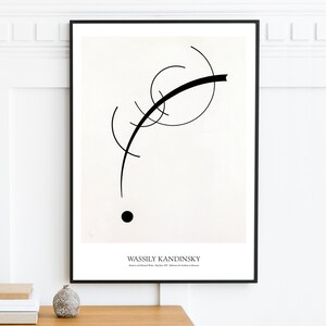 May include: Black and white abstract art print featuring a black curved line and a black circle on a white background. The print is framed in a black frame and has the text "Wassily Kandinsky" at the bottom.