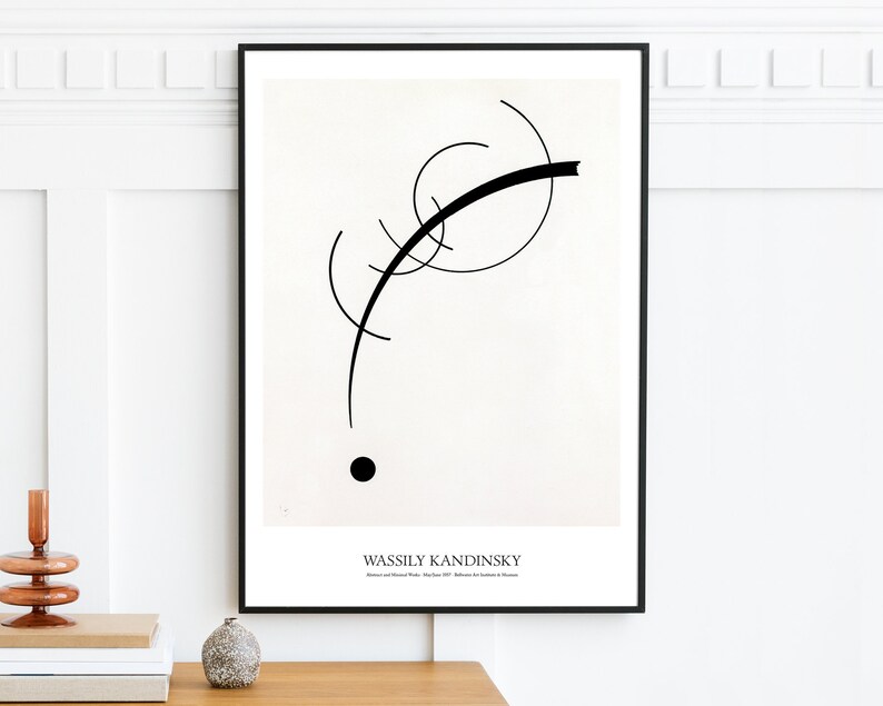 May include: Black and white abstract art print featuring a black curved line and a black circle on a white background. The print is framed in a black frame and has the text "Wassily Kandinsky" at the bottom.