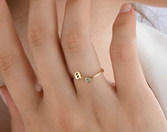 May include: A gold ring with a single small diamond and the letter "a" on the band.