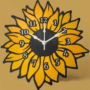 May include: A wooden sunflower clock with yellow petals and a black center. The clock face features black numbers and white clock hands. The clock is a decorative item.