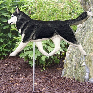 May include: Black and white wooden husky dog garden stake. The dog is running with its tongue out. The stake is made of wood and is painted to look like a husky.