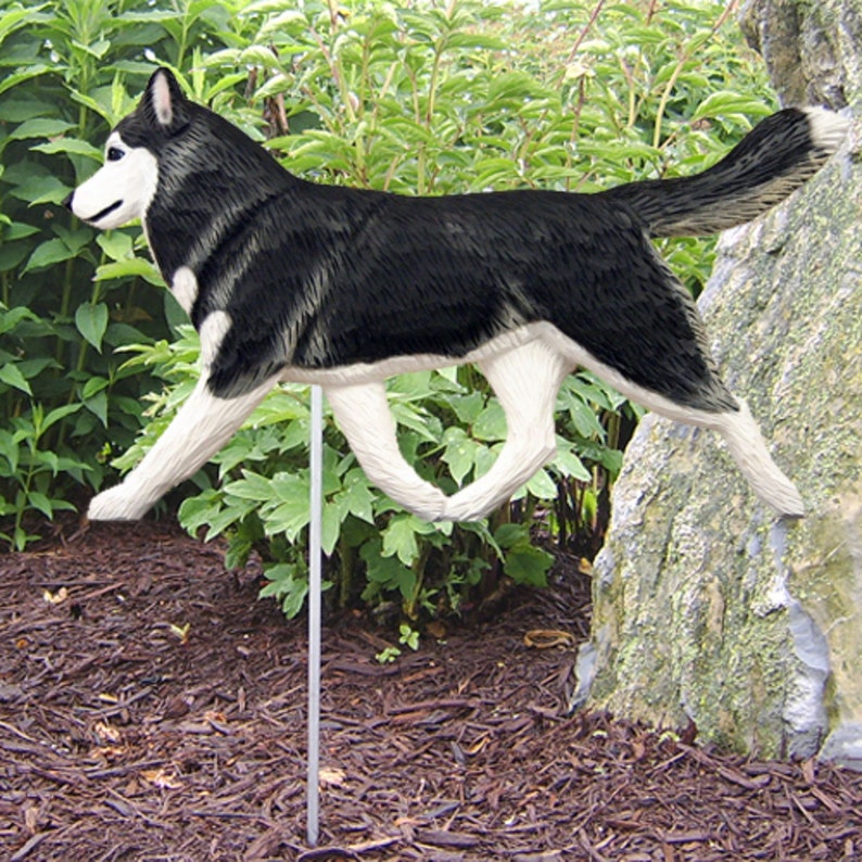 May include: Black and white wooden husky dog garden stake. The dog is running with its tongue out. The stake is made of wood and is painted to look like a husky.