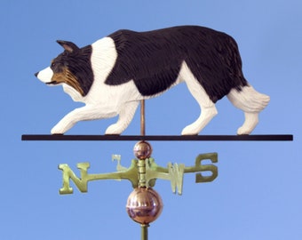 May include: A black and white border collie weathervane with a black metal base and a gold compass rose. The weathervane is mounted on a green pole.