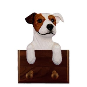 May include: A wooden coat rack with two hooks features a Jack Russell Terrier dog head sculpture. The dog is white with brown markings and has a friendly expression.