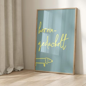 Pode incluir: Uma impress&atilde;o emoldurada com fundo azul claro e texto amarelo que diz "herein-gedackett". Um dachshund amarelo de desenho animado est&aacute; na parte inferior da impress&atilde;o.