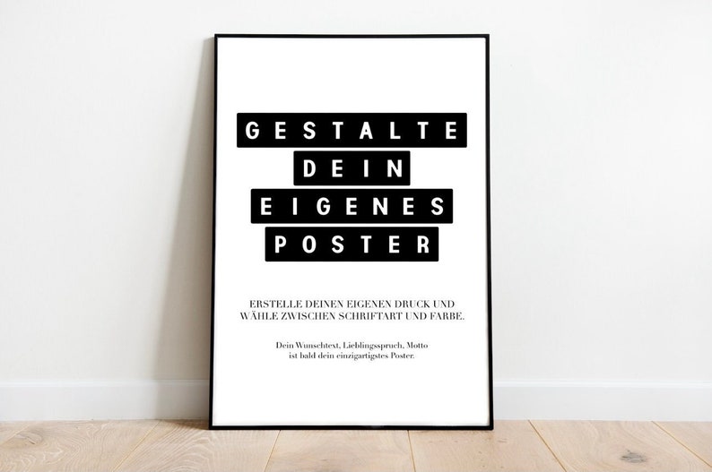 May include: A framed poster with black text on a white background. The text reads "GESTALTE DEIN EIGENES POSTER" in a bold, blocky font. Additional text below encourages customization of print style and color.