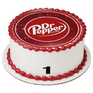 May include: A round white cake decorated with red frosting and a Dr. Pepper logo. The cake has a red border and the number 1 in black. The Dr. Pepper logo is in a red circle with white text.