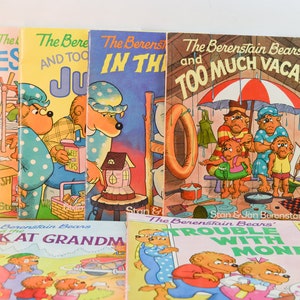 May include: A collection of ten vintage children's books featuring the Berenstain Bears. The books have colourful covers with illustrations of the bears in various situations. The titles include "And the Mess", "And Too Much Juice", "In the Dark", "And Too Much Vacation", "Week at Grandma", and "Trouble With Money".