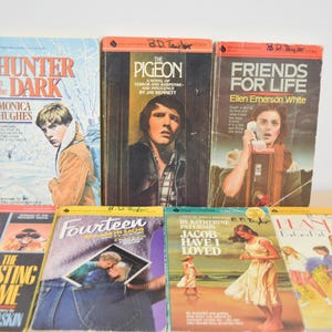 May include: A selection of vintage paperback books with vibrant covers. Titles include "Hunter in the Dark," "The Pigeon," "Friends for Life," "The Westing Game," "Fourteen," "Jacob Have I Loved," and "Hanch."