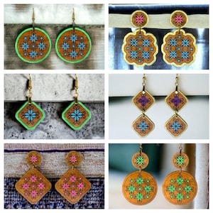 May include: A set of six pairs of wooden earrings with various geometric shapes and floral designs. The earrings are painted in shades of blue, green, pink, and purple.