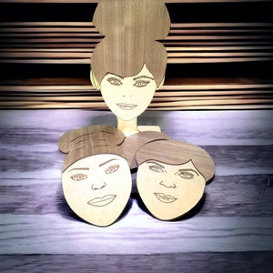 May include: Three wooden coasters featuring laser-cut portraits of women with different hairstyles. The coasters are made of light brown wood and have a natural wood grain finish.