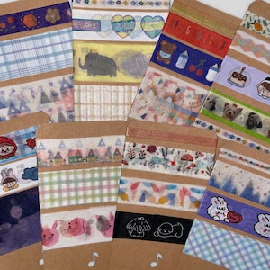 May include: A collection of decorative washi tapes with various designs. The tapes feature patterns like plaid, cartoon animals, and floral motifs. Some tapes have text, including the phrase "THE FUTURE IS ME". The color palette includes blues, pinks, and greens.