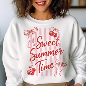 May include: White sweatshirt with a red and pink design. The design includes the text "Sweet Summer Time" with cherries and bows. The sweatshirt has a crew neck and long sleeves.