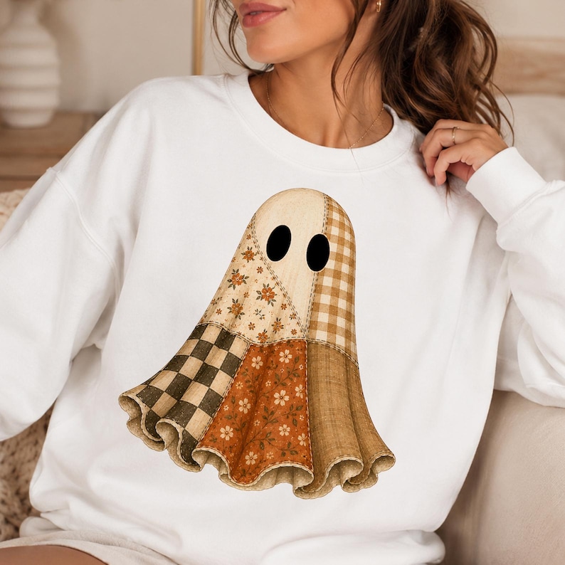 Puede incluir: Una sudadera blanca de cuello redondo con un gr&aacute;fico central de un fantasma compuesto por varios patrones de tela. El dise&ntilde;o del fantasma incluye secciones de cuadros vichy en marr&oacute;n y crema, estampados florales y un patr&oacute;n de cuadros, todo con dos ojos ovalados negros.