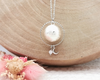 May include: Silver-toned necklace featuring a large, textured, spherical pendant within a twisted metal ring. A small moon and a round bead dangle below. The necklace hangs on a delicate chain, perfect for everyday wear.
